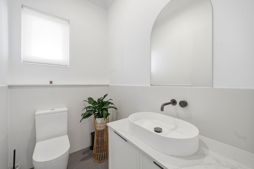Powder room with vessel basin and arched mirror