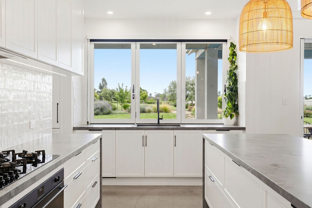 White shaker kitchen with garden outlook