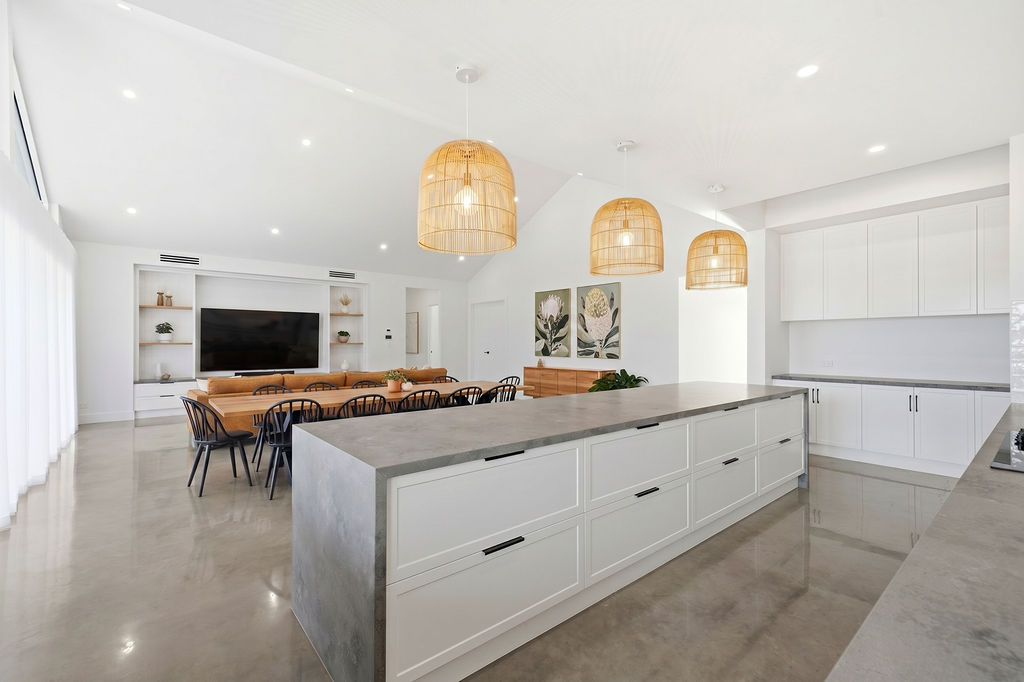 Shaker kitchen with concrete island and rattan pendants