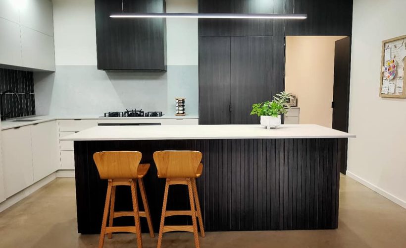 Modern kitchen with black island and white cabinetry