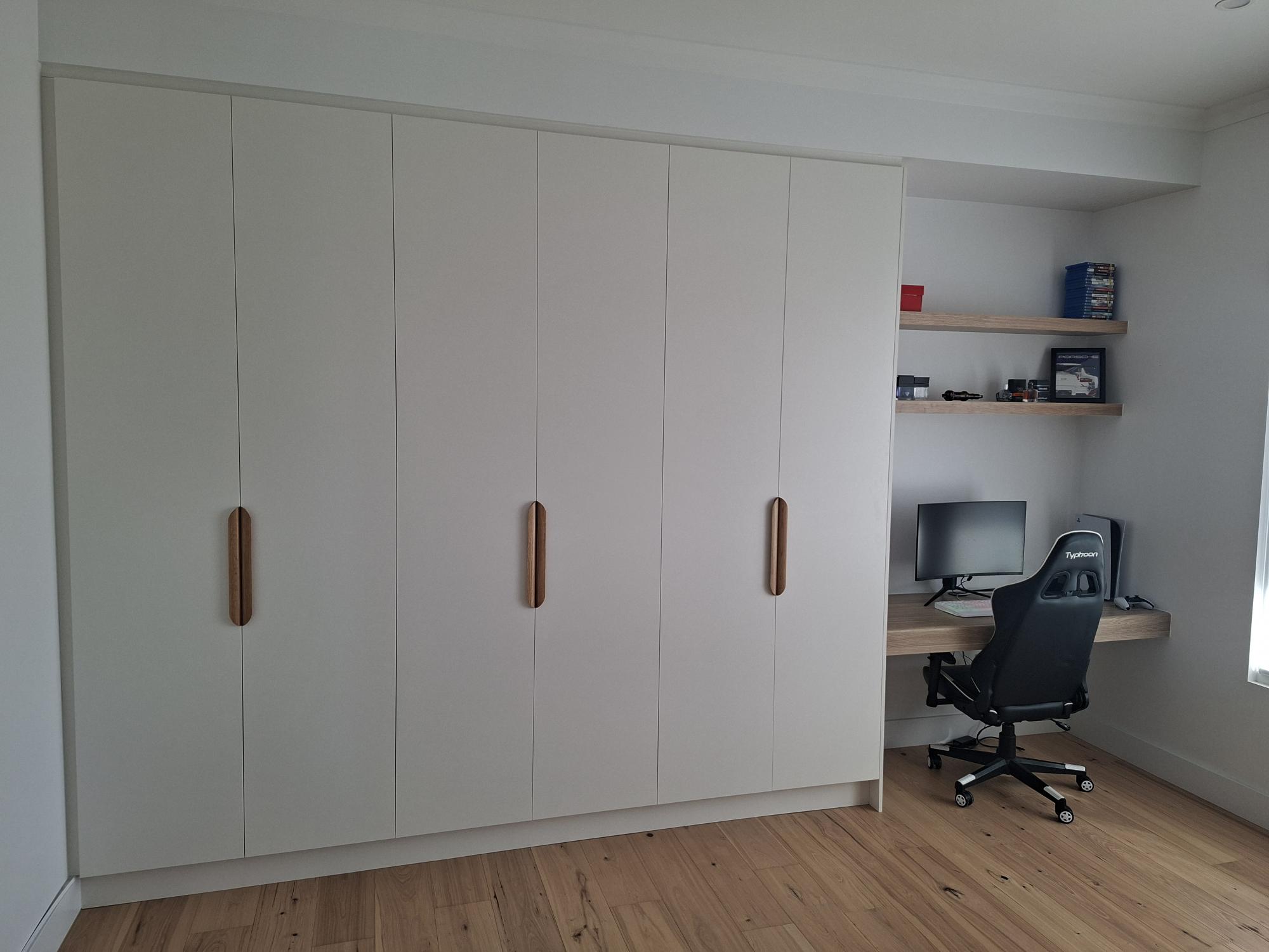 Built in wardrobe with timber handles and integrated home office desk
