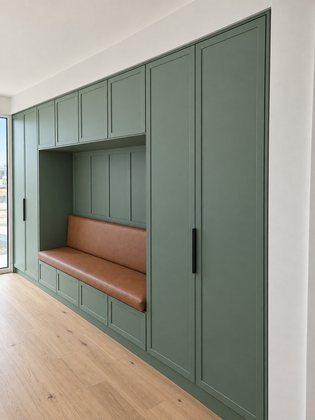 Green shaker mudroom storage with integrated bench seating and linen cupboards